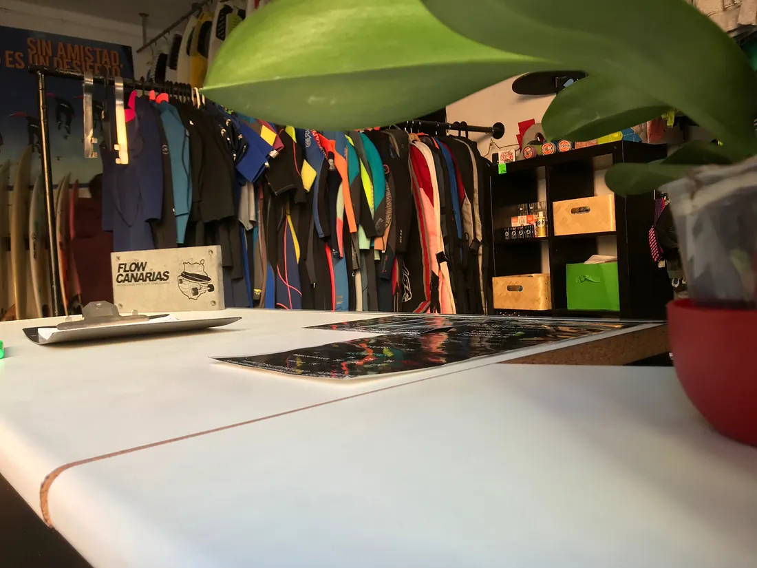 Interior del local con neoprenos colgados y tablas